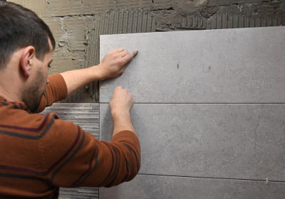 Carreleur amateur qui pose du carrelage et essaie d'éviter de faire des erreurs